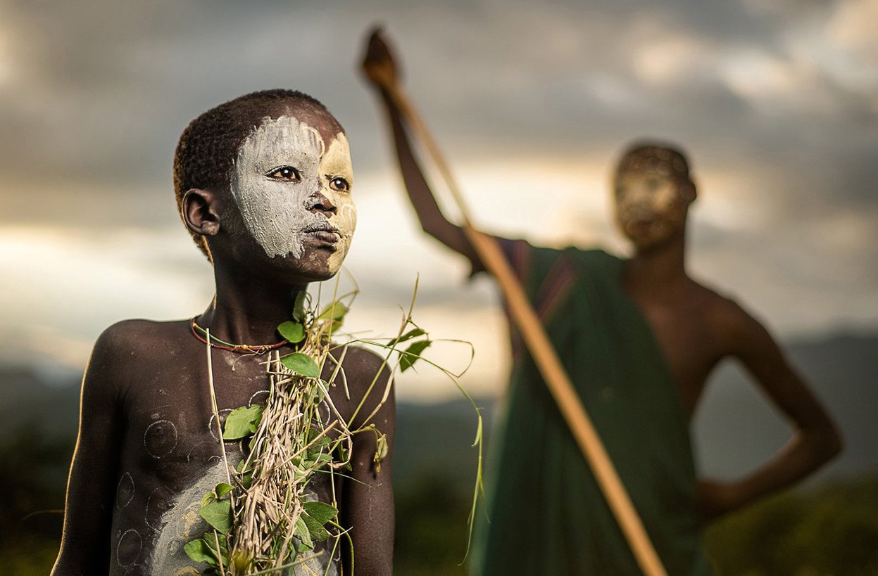 A boy of the nomadic Suri tribe of Ethiopia, in traditional face-body paint and attire Human Diversity