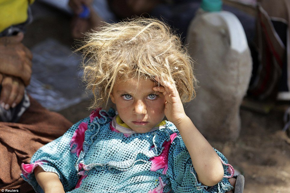A girl from the minority Yazidi sect rests at the Iraqi-Syrian border crossing in Fishkhabour, Dohuk province after fleeing Isla Human Diversity
