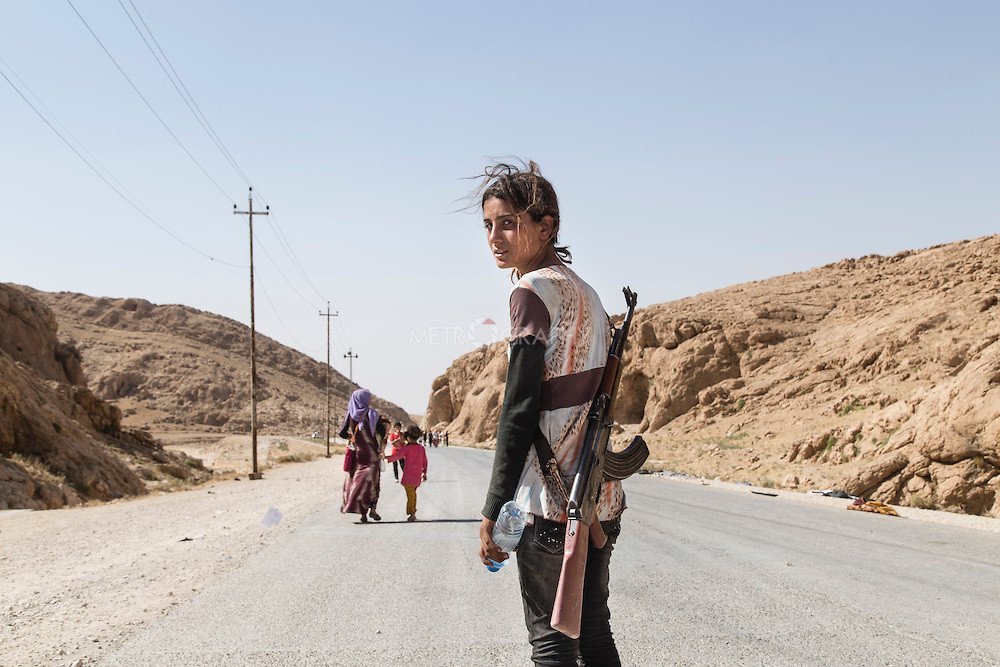 Yezidi girl carries an assault rifle to protect her family against ISIS Human Diversity